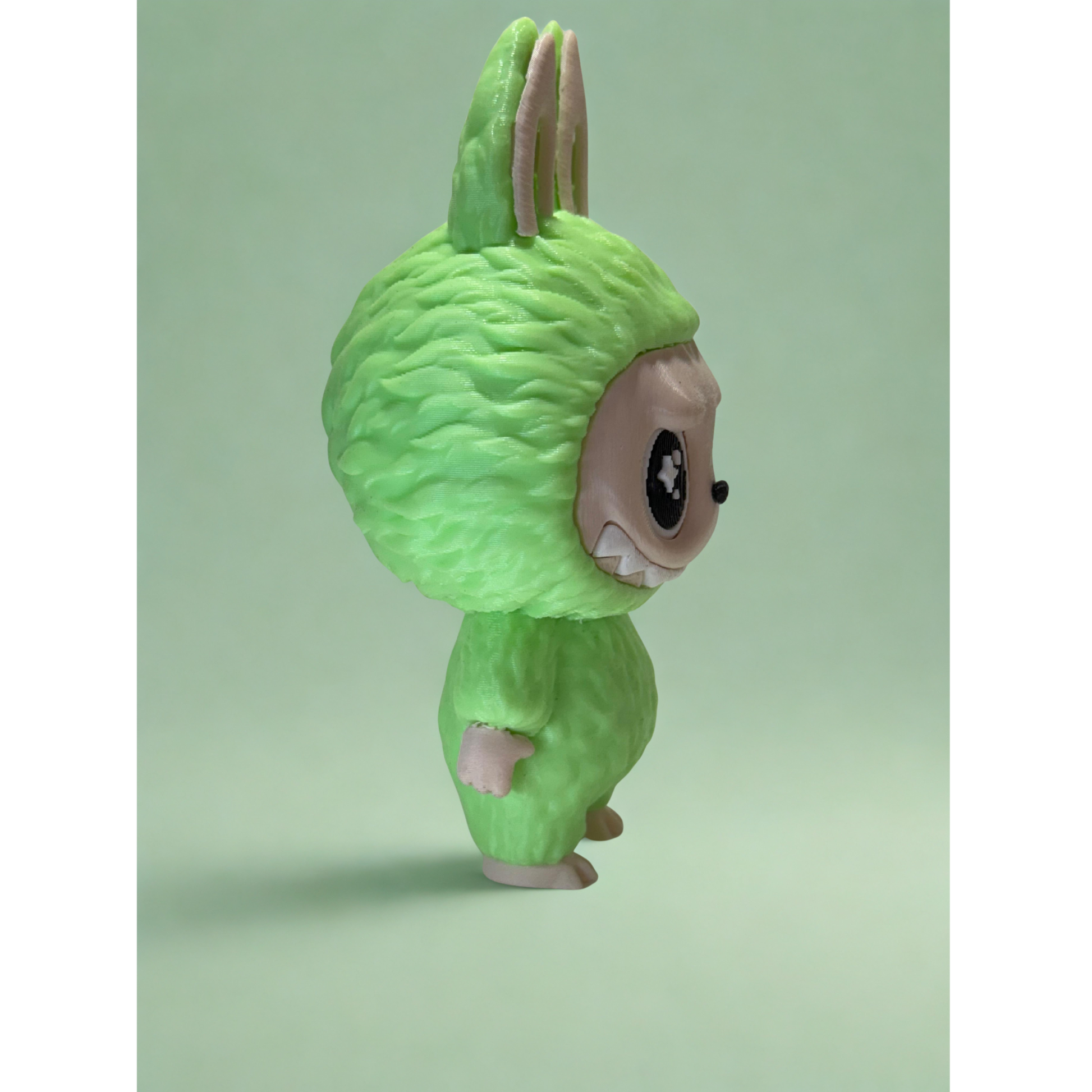 Glow-in-the-dark Labubu figurine illuminating message plaque in the dark, showcasing PLA-glow filament effect.